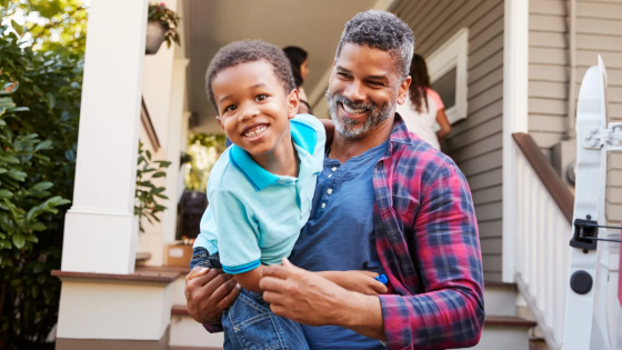 Father carrying son down outdoor stairs