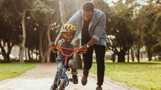 Father teaches son how to ride bike