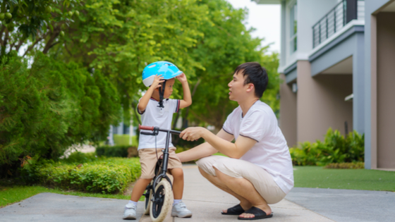 Father teaching son how to ride bike