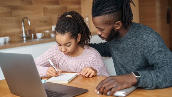 Father working with daughter on homework