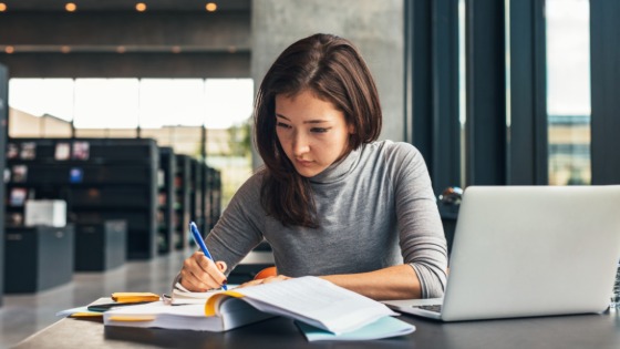 Female student taking notes at a library