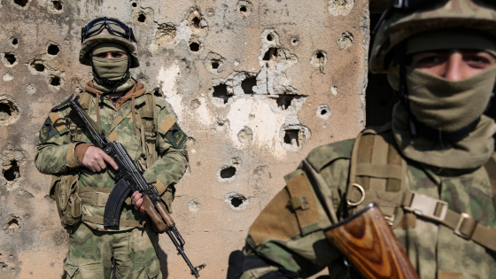 Fighters of Hayat Tahrir al-Sham militant group hold their weapons at the front lines of the armed opposition overlooking the Syrian government-held city of Aleppo