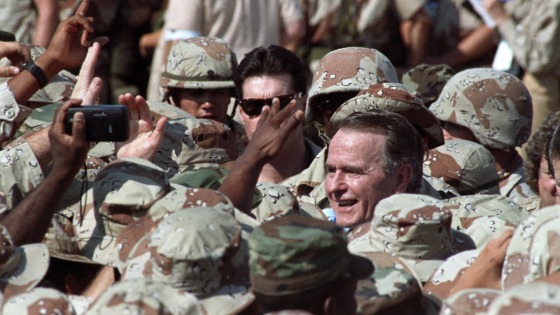 George H.W. Bush is surrounded by a sea of U.S. military personnel as he greets troops