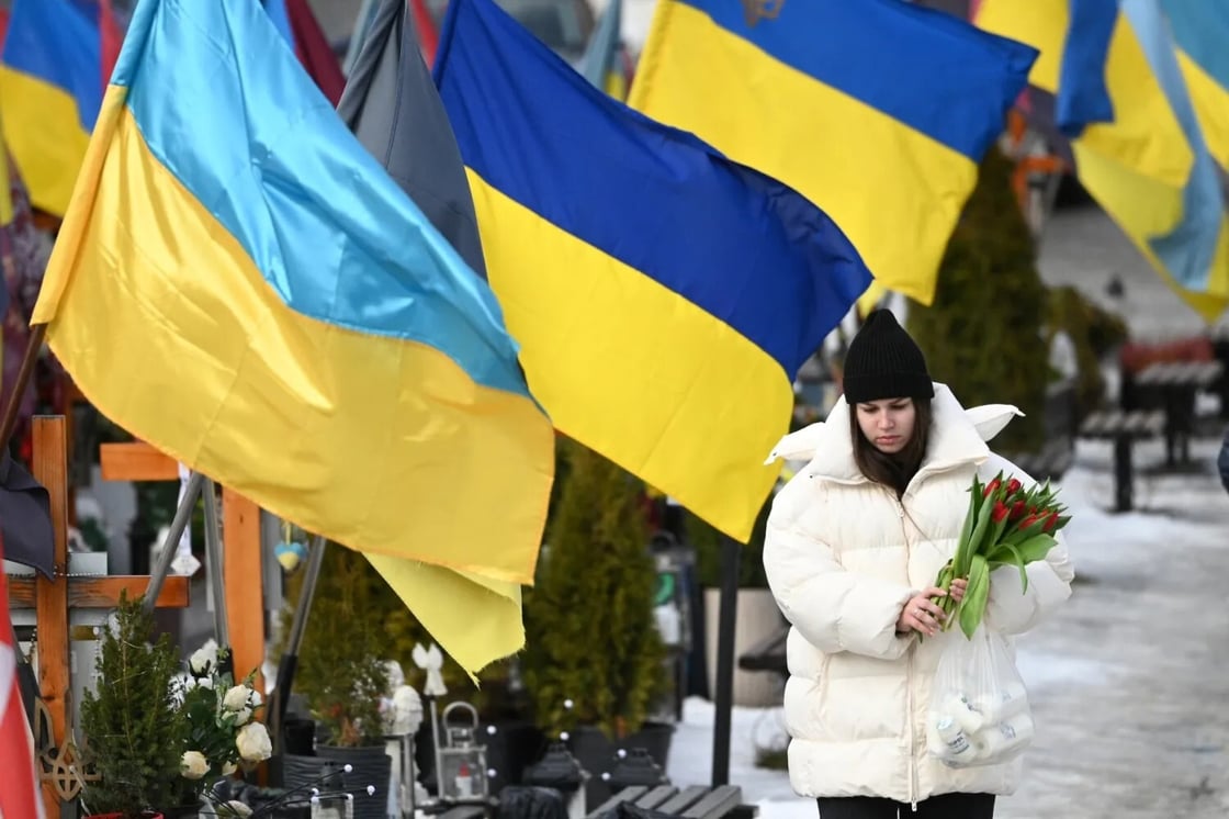 A mourner holds flowers on Valentine's Day at the Lychakiv Military Cemetery in Lviv, on February 14, 2026, amid the Russian invasion of Ukraine. (Yuriy Dyachyshyn/AFP via Getty Images)
