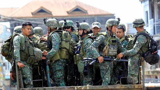 Government troops ride on a military truck along the main road of Mapandi district in Marawi City.