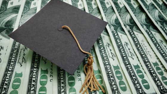 Graduation cap and one hundred dollar bills.