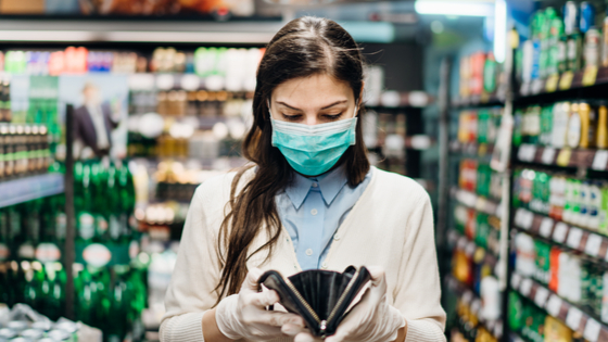 Grocery store shopper with mask opens her purse.