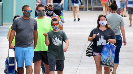 Guests wear face masks while visiting the Disney Springs shopping and dining district in Lake Buena Vista