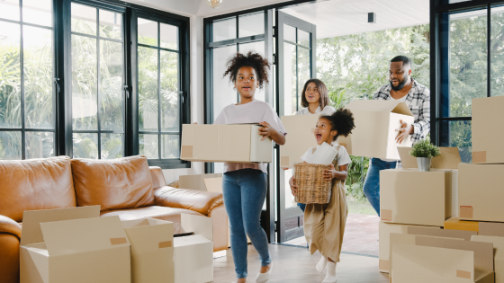 Happy family moves boxes into new house