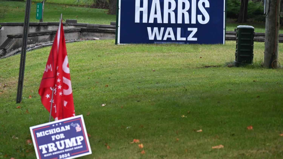 Harris-Walz and Trump signs on grass.