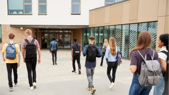 High school students walk into college building