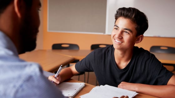 High school tutor instructs young male student.