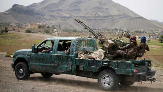 Houthi fighters man a machine gun mounted on a military truck