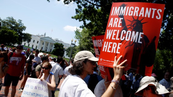 Immigration activists hold signs during a rally