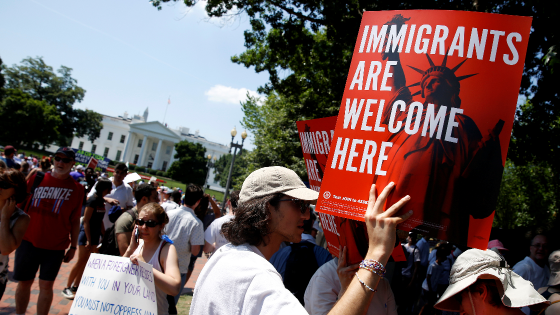 Immigration activists hold signs during a rally