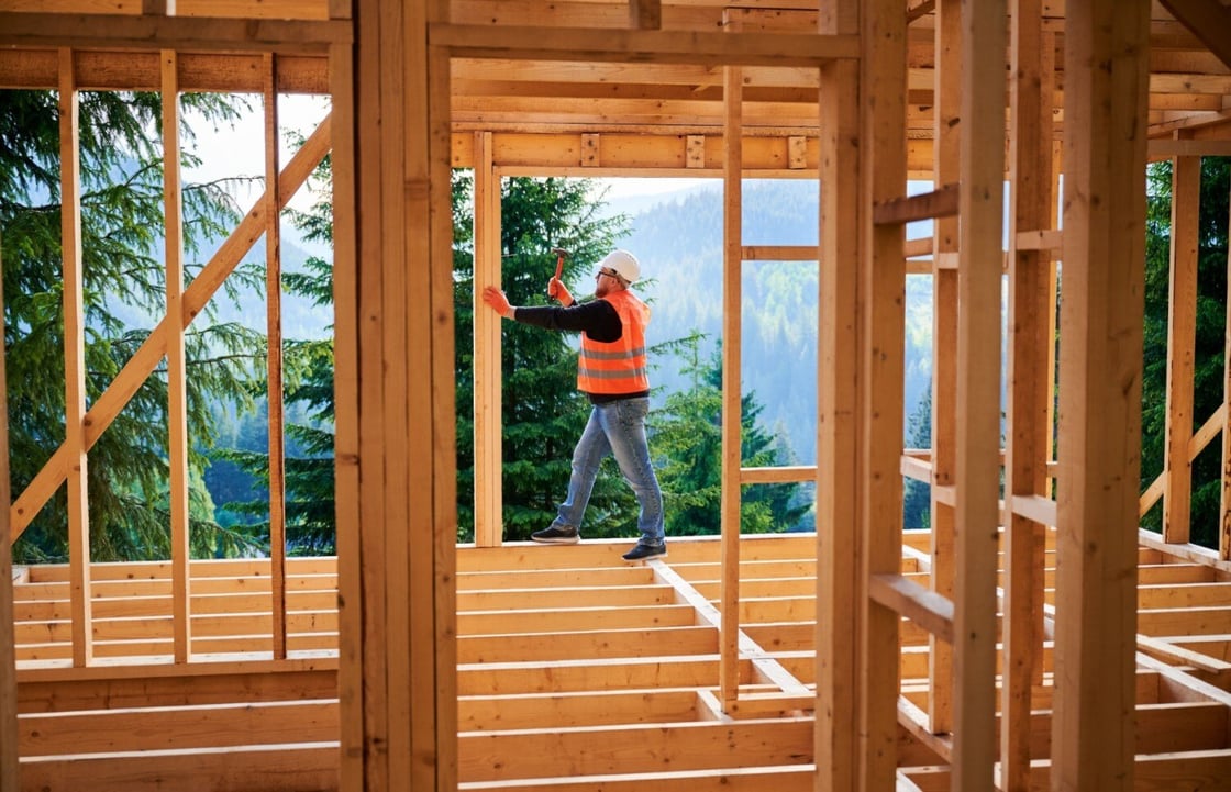 Carpenter working on the frame of a house. 