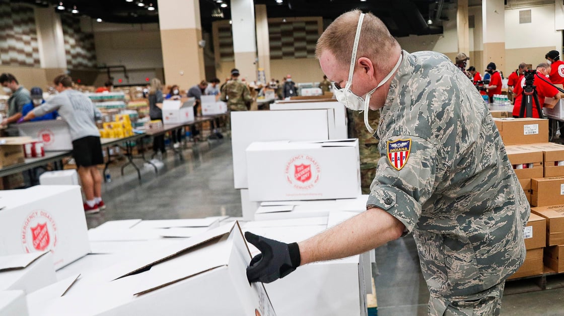 Indiana National Guard Second Lt. Joseph Parnin picks up empty boxes at Lucas Oil Stadium