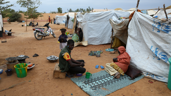 Individuals sit outside tent in Mali