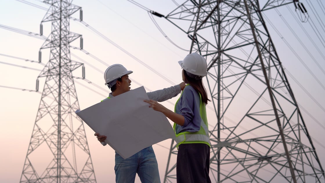 Two electrical engineers in front of a power line