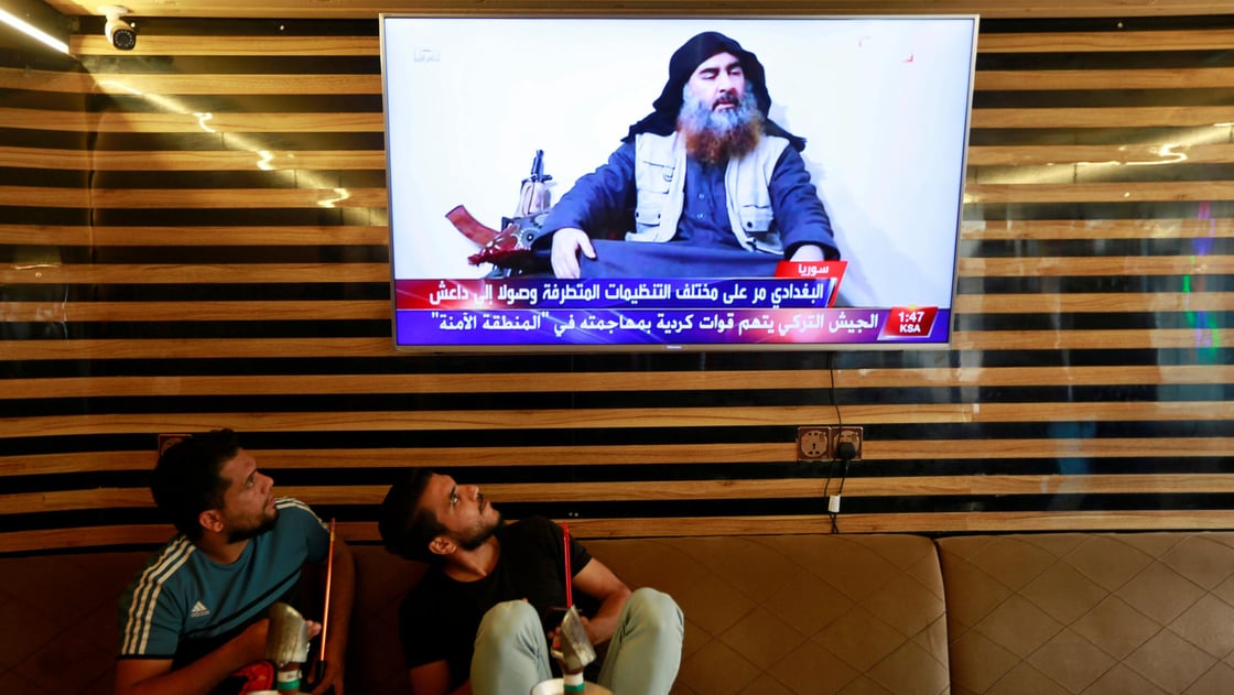 Iraqi youth watch the news of Islamic State leader Abu Bakr al-Baghdadi death, in Najaf