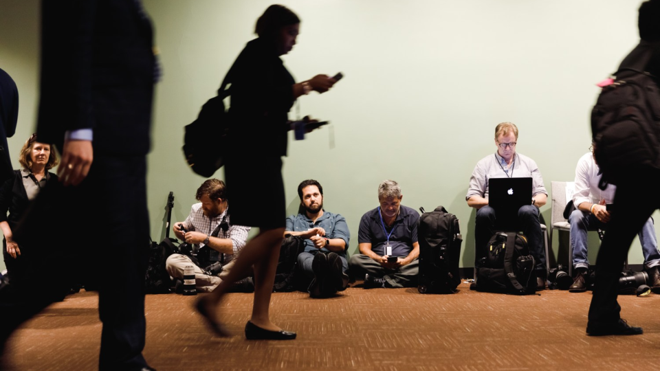 Journalists sitting together in a hallway.