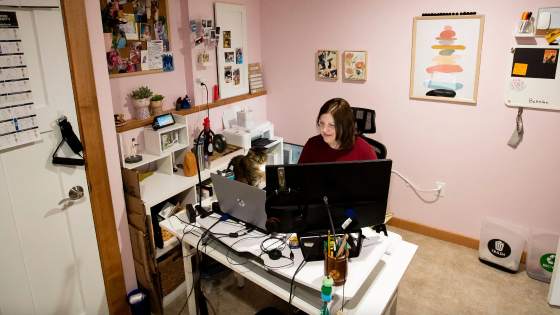 Julie De Leon and her cat Lily look at the computer as Julie works from her home