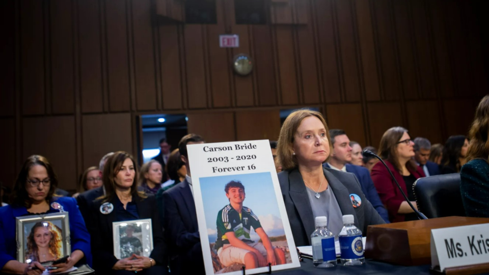 Kristin Bride, Survivor Parent and Social Media Reform Advocate, sits next to a photo of her 16-year-old son Carson Bride