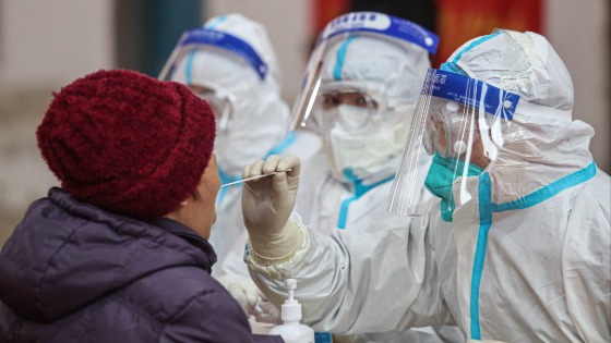 Medical workers collect throat swab from residents in Shenyang city