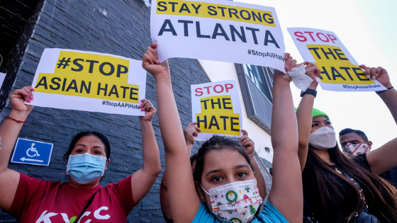 Melanie Bolanos holds a sign to protest hate crimes against Asian Americans