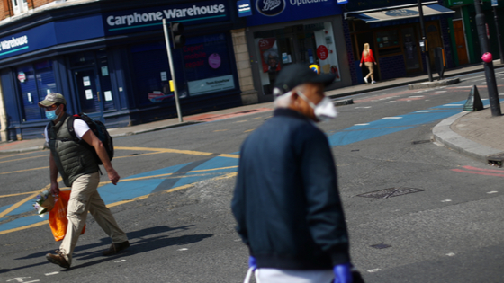 Men wearing protective face masks are seen in Tooting, following the outbreak of COVID-19.