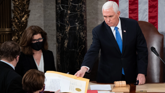 Mike Pence hands the electoral certificate from the state of Arizona to Amy Klobuchar