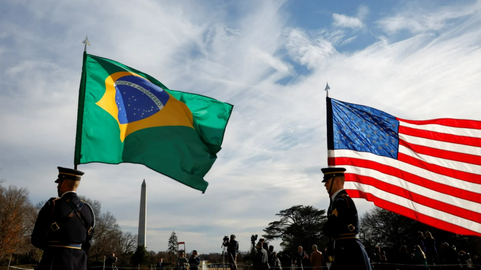 Military personnel carry U.S. and Brazilian flags