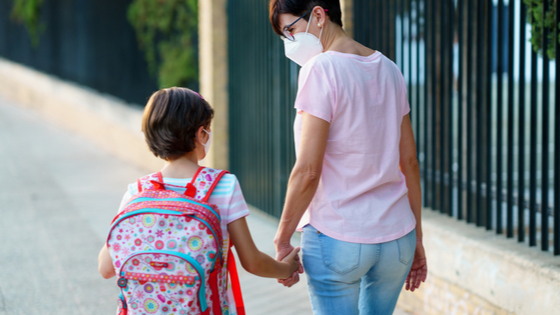 Mother walking daughter to school amid COVID-19.