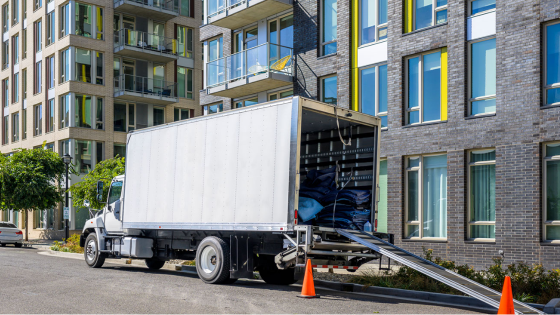 Moving truck parked in front of an apartment building