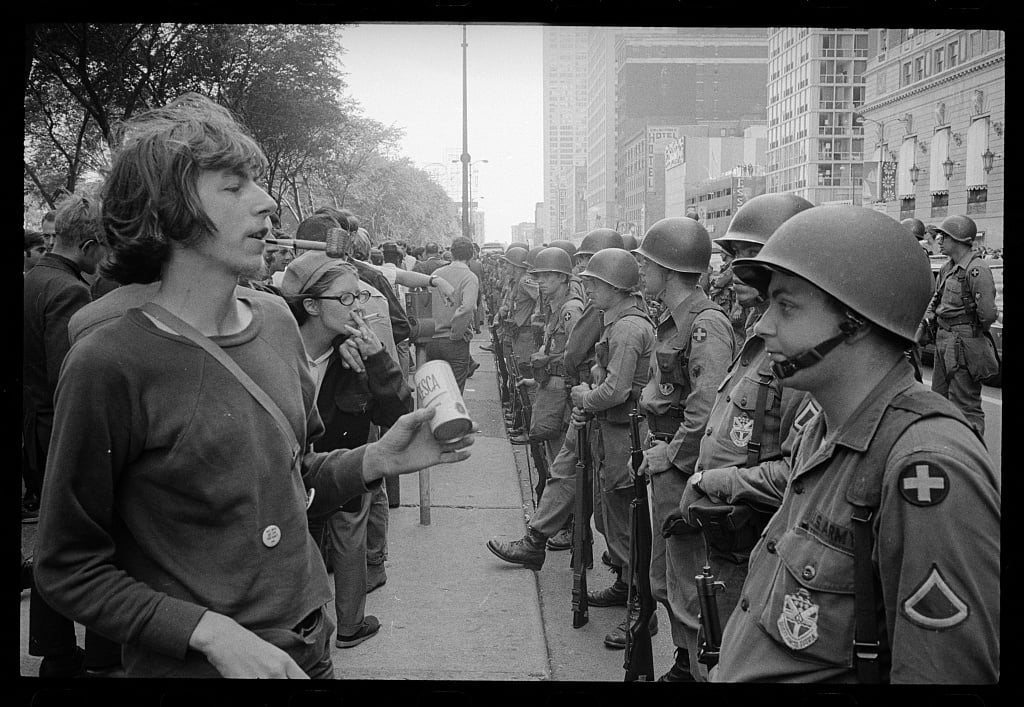 Young man__standing_in_front_of_a_row_of_National_Guard_soldiers,_across_the_street_from_the_Hilton_Hotel_at_Grant_Park,_at_the_Democratic_National_Convention_in_Chicago,_August_26,_1968