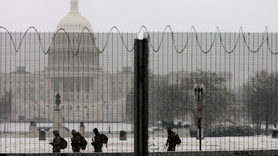 National Guard members stand in the snow on duty at the Capitol