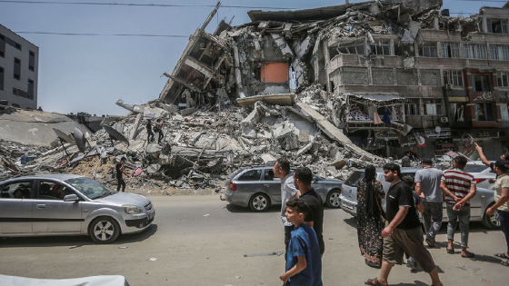 Palestinians inspect damaged buildings that were hit by Israeli airstrikes