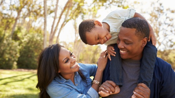 Parents carry child through park