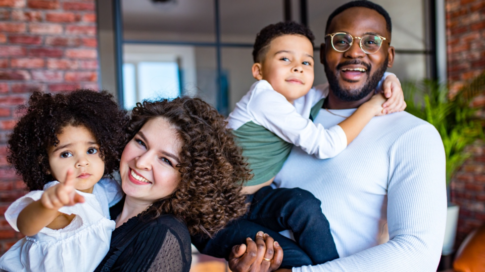 Parents pose for a photo with their children.