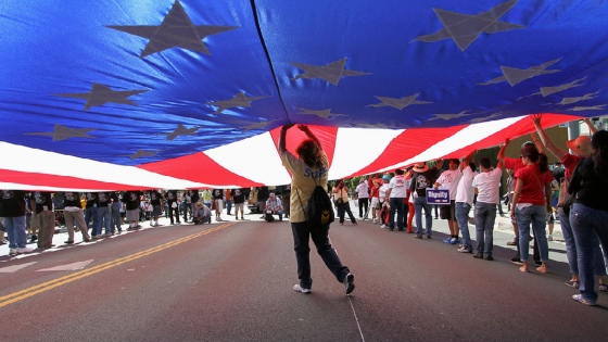 Participants carry a large U.S. flag during a march for immigration reform in Hollywood