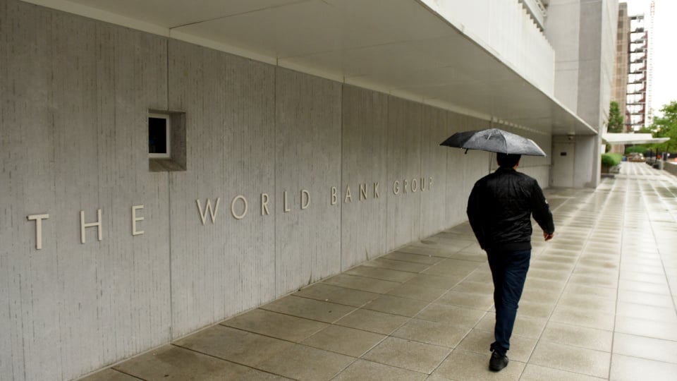 Pedestrian with an umbrella near The World Bank main Building in Washington, DC.