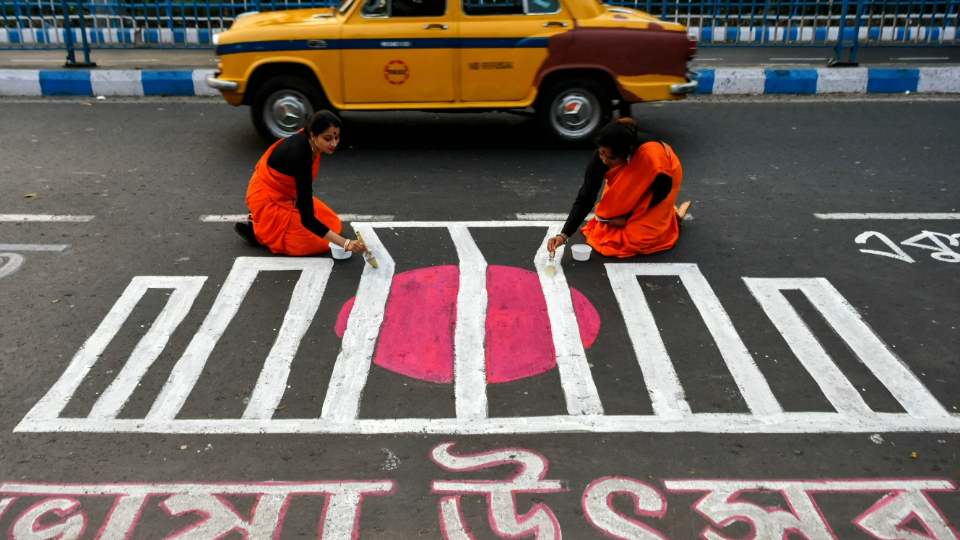 People are seen writing various messages in Bengali on a road to commemorate International Mother Language Day