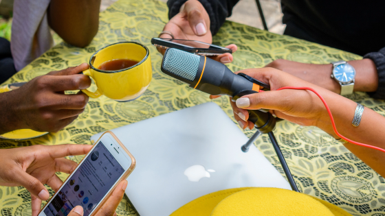 People around a table with mics for podcasting