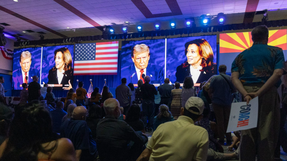 People at the Mesa Convention Center watch former President Donald J. Trump and Vice President Kamala Harris debate on September 10, 2024