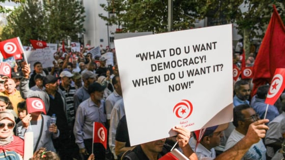 People chant slogans while holding up Tunisian flags, during a demonstration held by the National Salvation Front