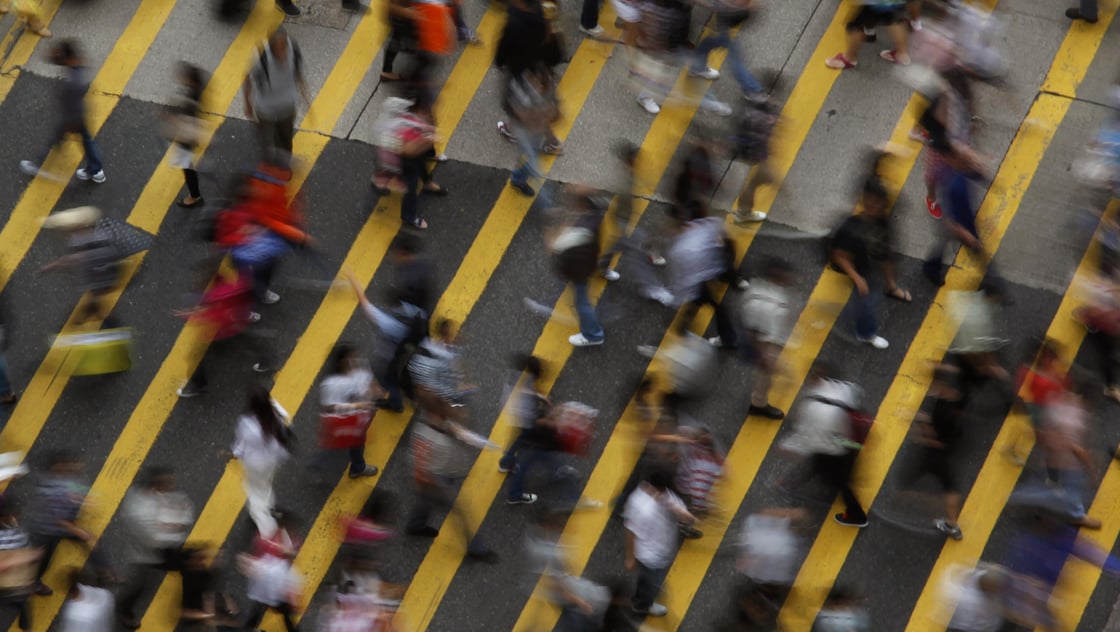 People cross a street in Mong Kok district in Hong Kong