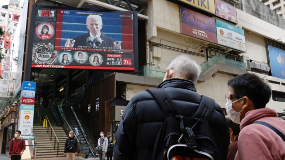 People look at a TV screen showing news of U.S. President Joe Biden after his inauguration