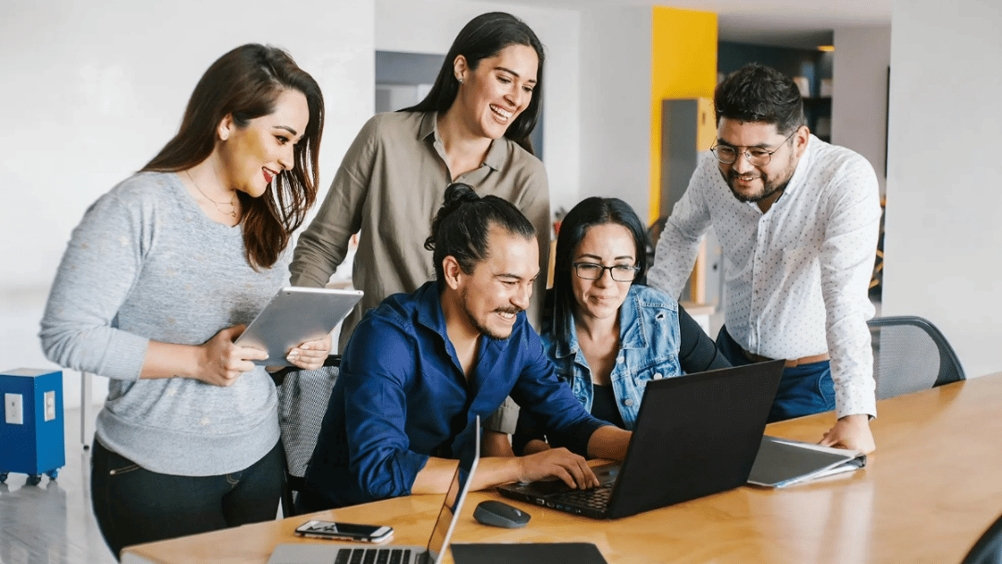 People look at laptop screen in office setting