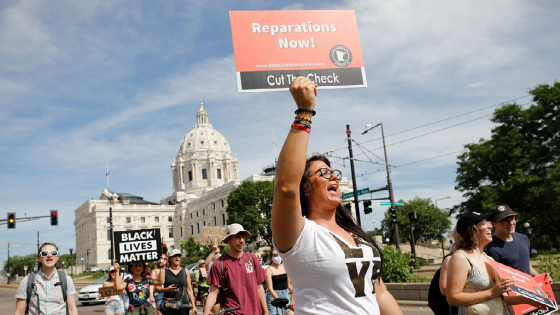 People march past the Minnesota State Capitol during the Reparations Juneteenth Celebration