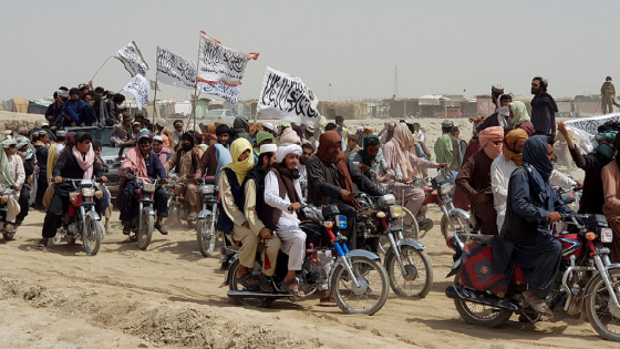 People on vehicles, holding Taliban flags, gather near the Friendship Gate crossing point in the Pakistan-Afghanistan border town of Chaman